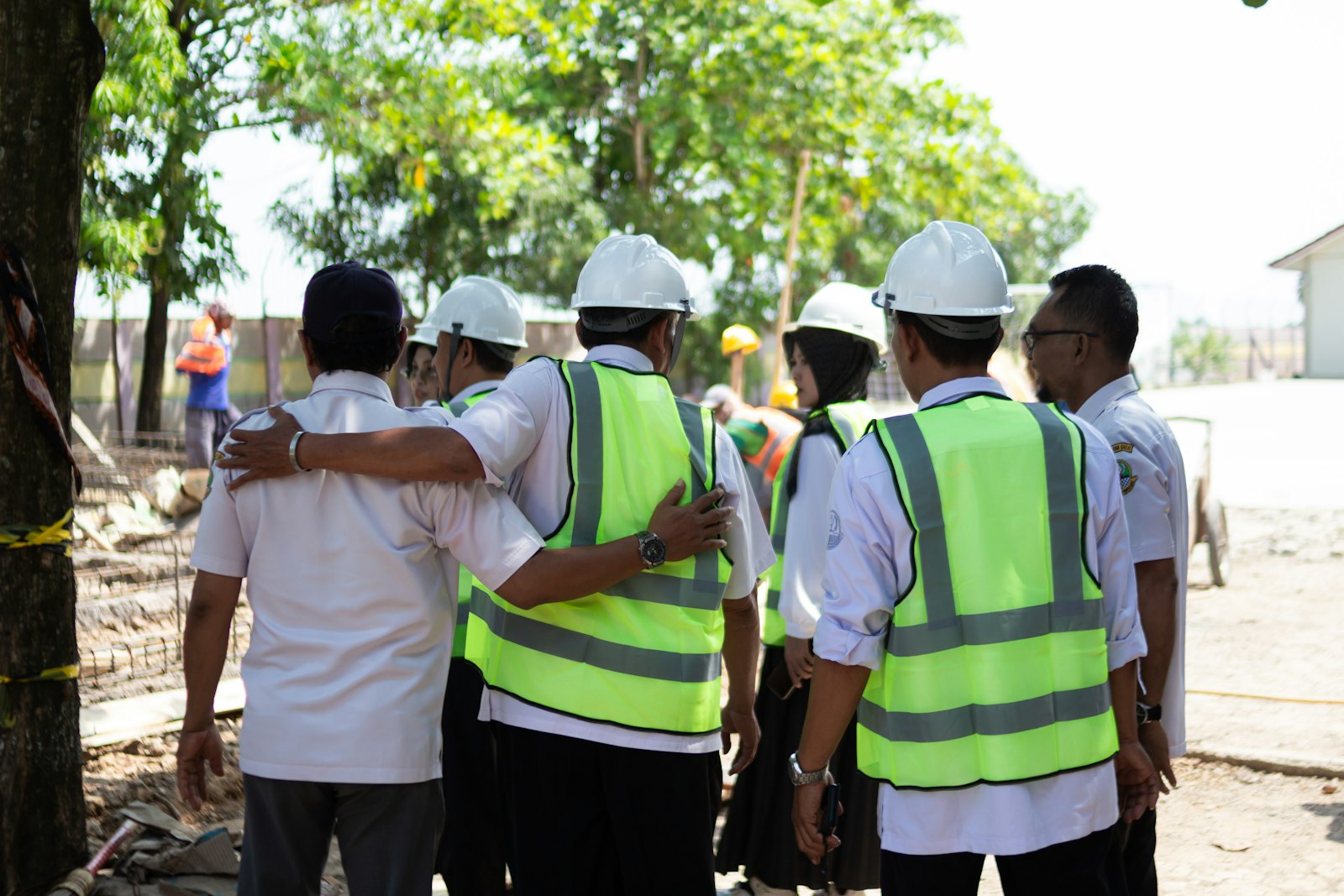 Construction crew in hard hats and hi-vis vests gathered on site